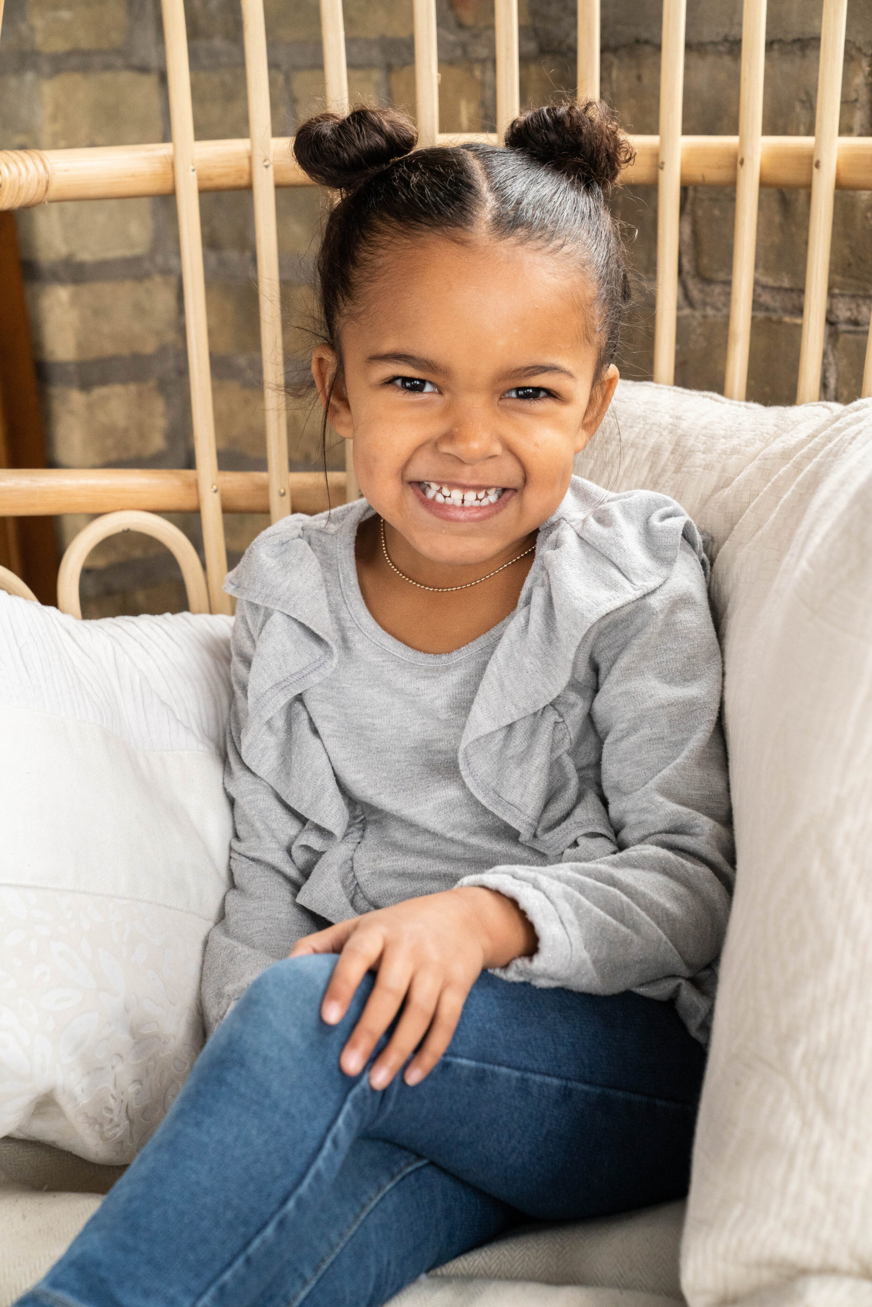 Little girl sitting in a chair and smiling - family session