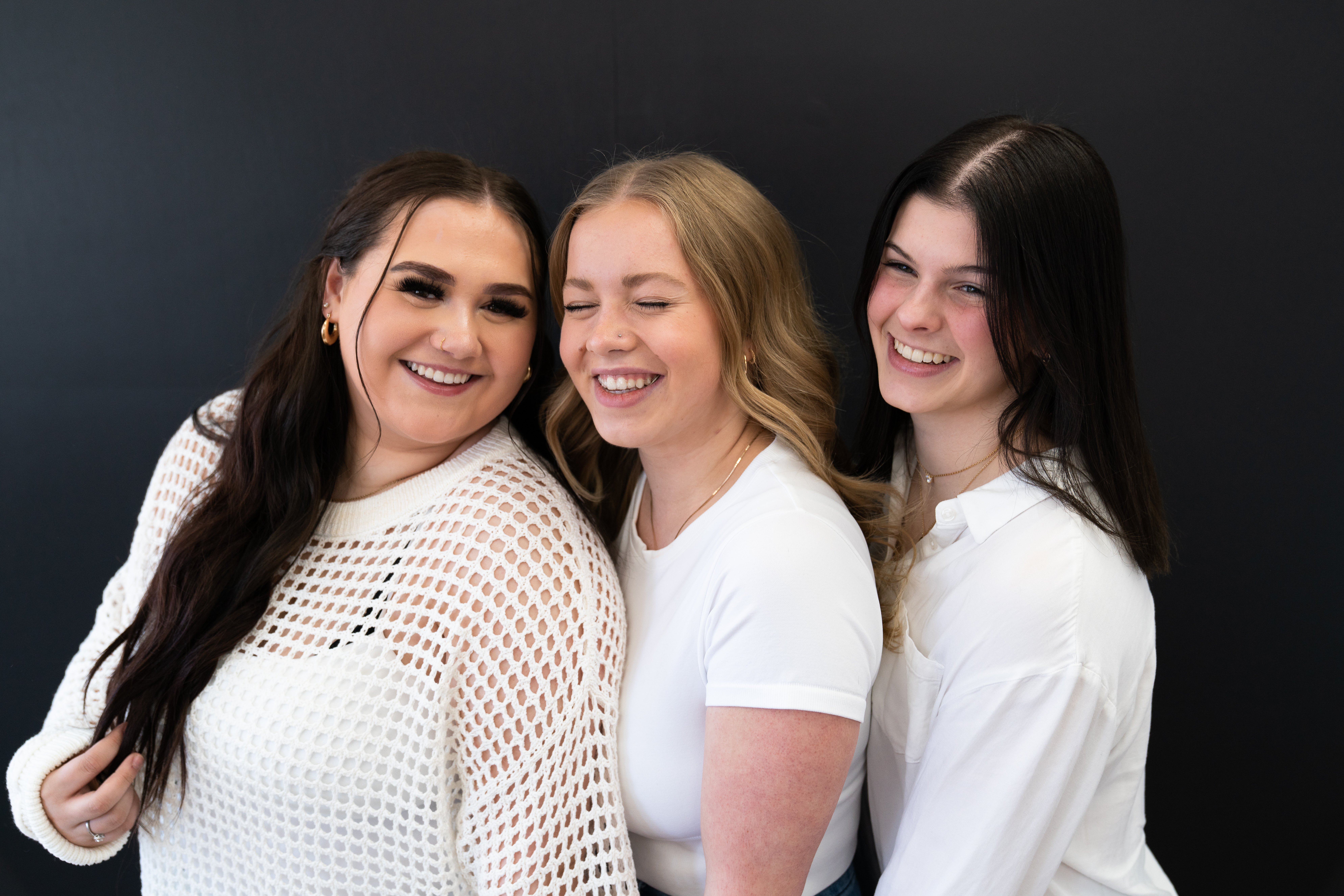 Three girls posing for a photo during their senior rep photo shoot at a studio in Downtown Lakeville, Minnesota