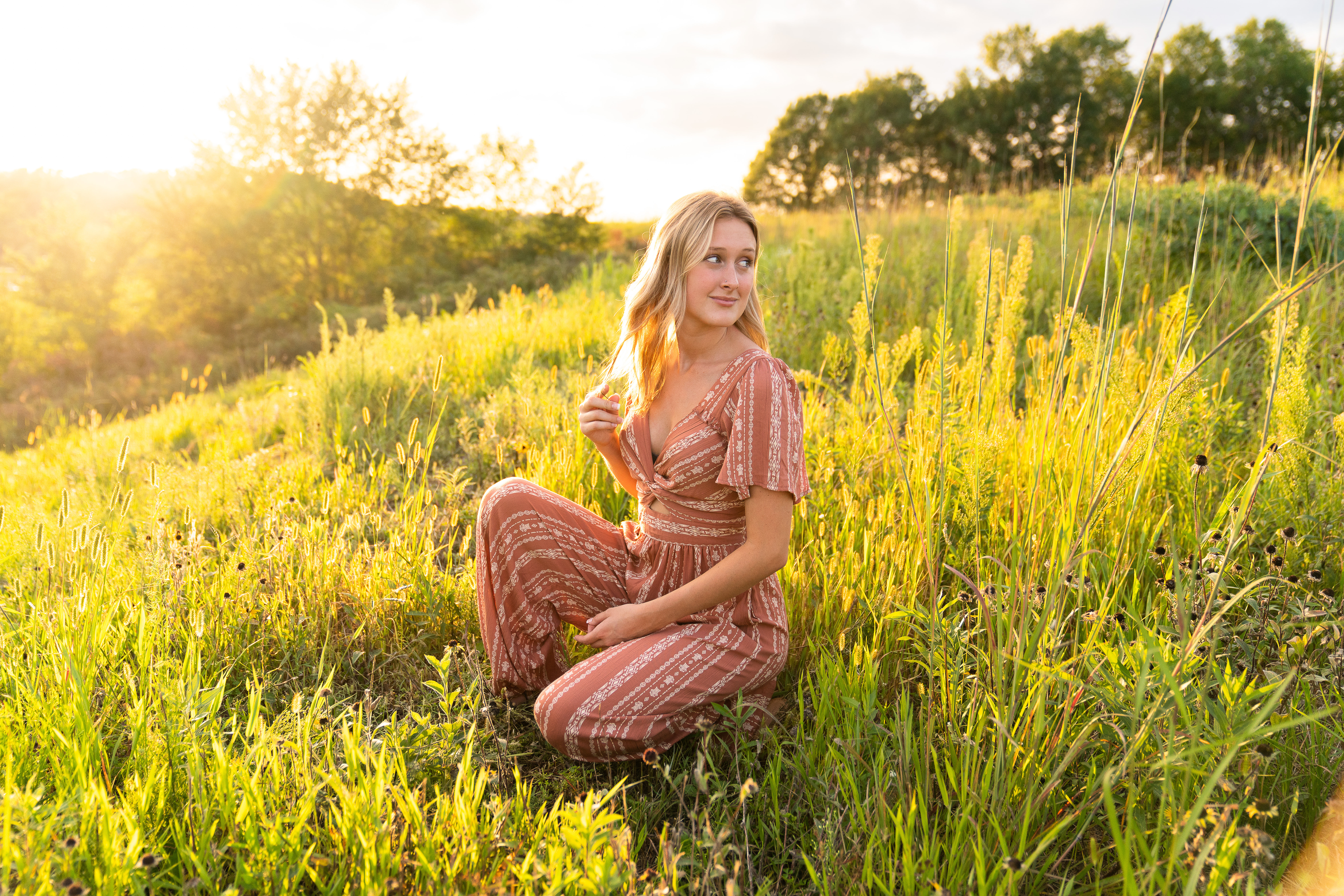 Girl posing for her senior pictures in a field at Lebanon Hills Regional Park in Eagan, Minnesota