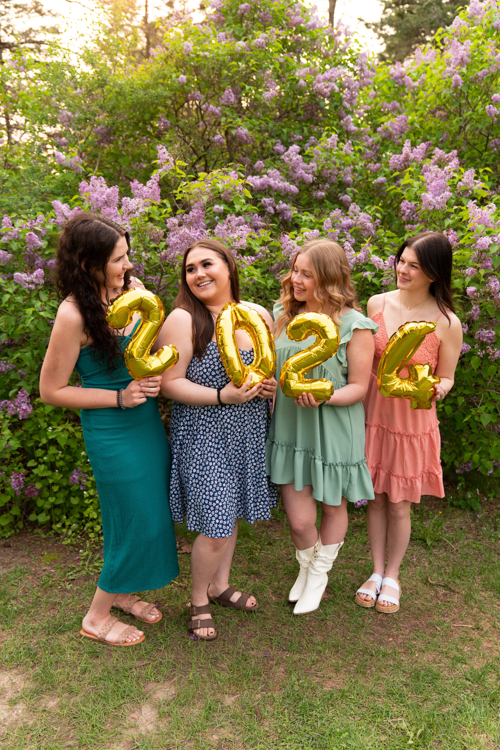 a group of girls posed holding balloons that show "2024".