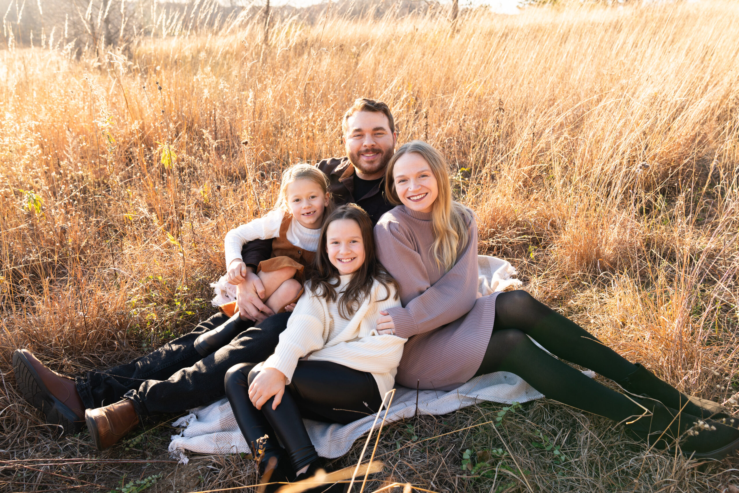 Family poses together on a blanket during their family pictures at Whitetail Regional Woods in Farmington, Minnesota.