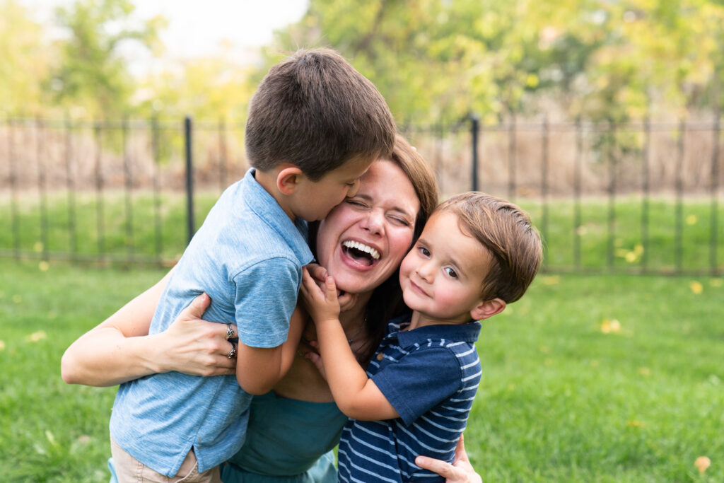Two boys love on their mom during their summer family pictures.
