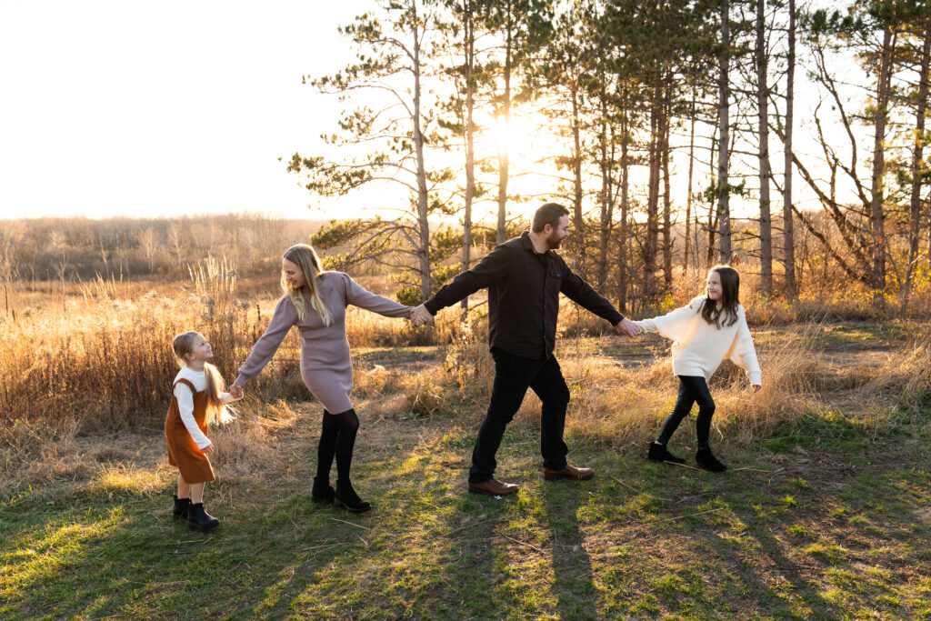 A family of four play follow the leader during their family photo shoot at Whitetail Woods Regional Park in Farmington, Minnesota.