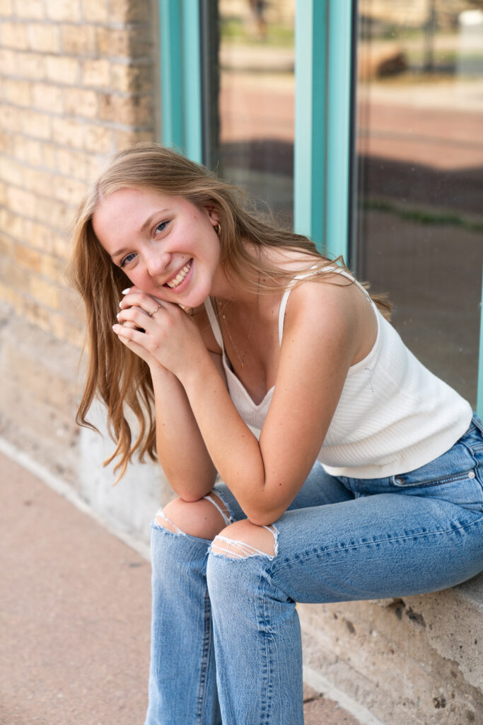 Teen girl smiles at the camera for her senior pictures in Downtown Minneapolis, Minnesota