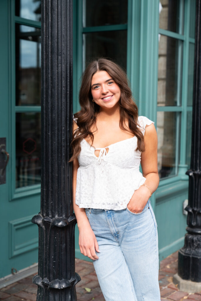 high school girl leans up against a pillar and poses for her senior photos - Kristen Elizabeth Photography